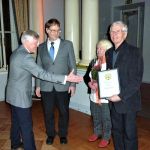 Sihteeri aloittaa onnittelun.. Risto esittelee kunniakirjaa..